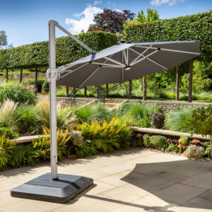 Hartman Caribbean 3.5m Round Cantilever Parasol With Water Fillable Base & LED Lights on a garden patio