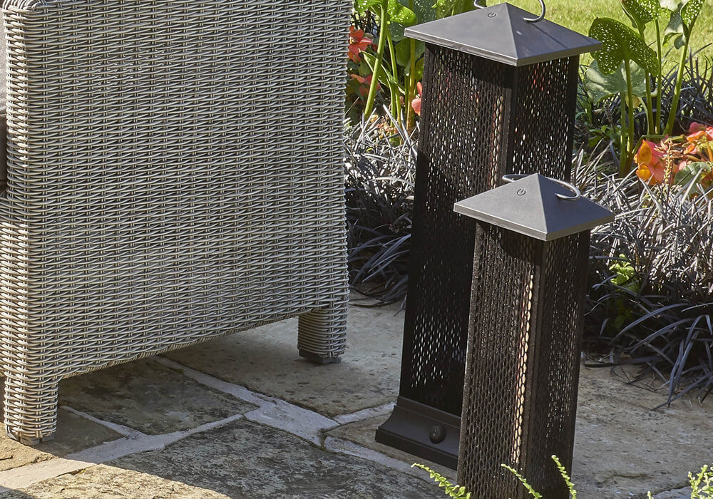 Kettler Universal Electric Lantern Heater 50cm on a garden patio next to larger Electric Lantern Heater and outdoor chair