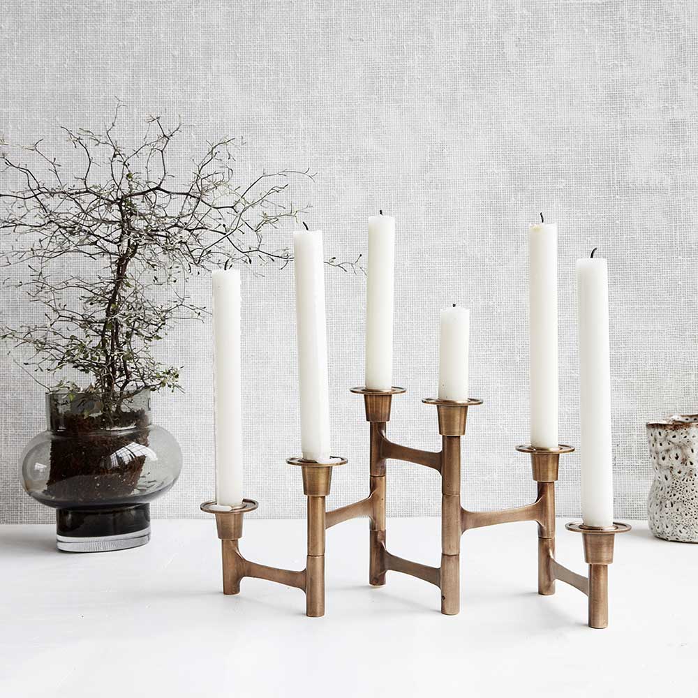 cleave candelabra on a white table with small black tree in the background