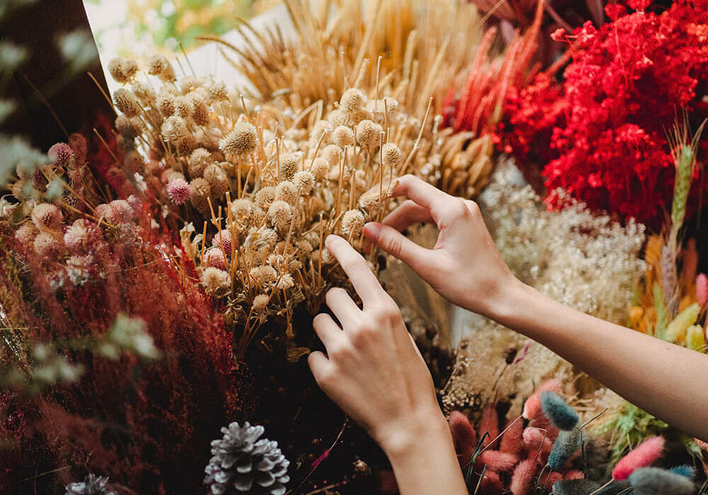 lady arranging colourful dried flowers