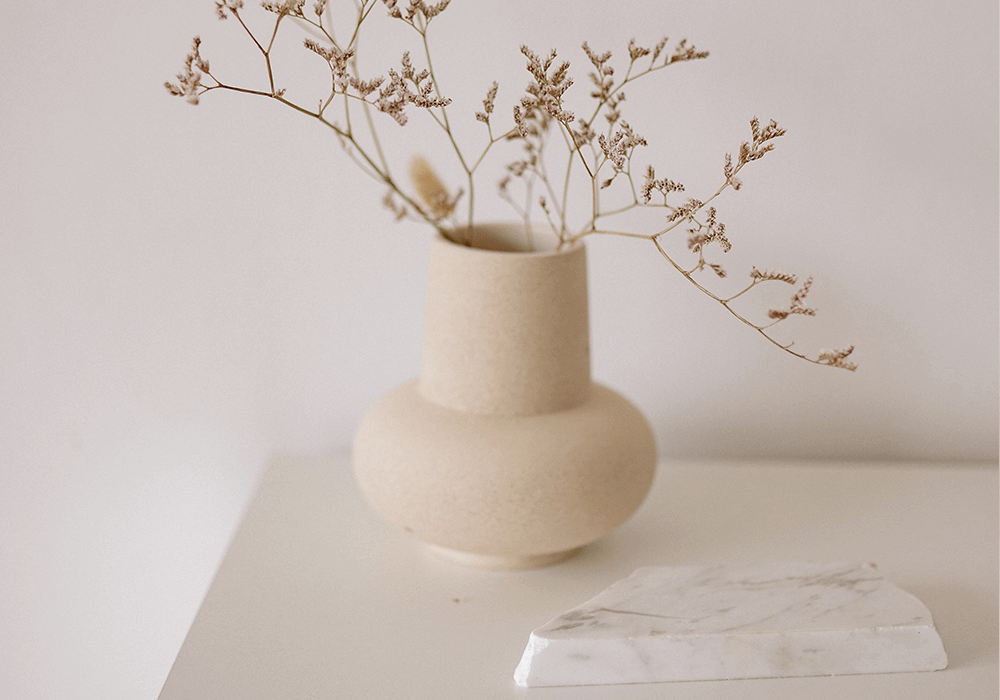 dried flowers in a cream vase