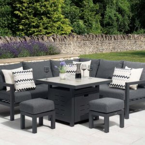 Bramblecrest La Rochelle Mini Corner Sofa Set With Fire Pit Ceramic Table with 2 x stools - Anthracite/Dark Grey on white patio in front of walled garden