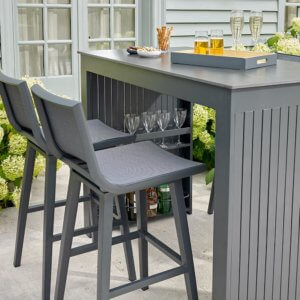 left hand view of Bramblecrest La Rochelle 4 Seat Rectangle Garden Bar Table Set - Anthracite/Dark Grey on outdoor patio with drinks on table