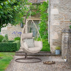 Bramblecrest Tetbury Teardrop Single Cocoon Hanging Chair on a gravel path in a garden