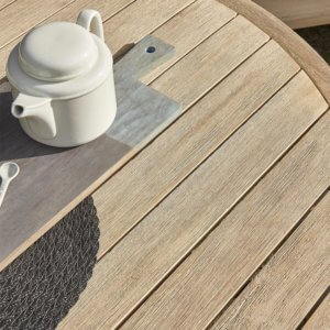 close up of wooden outdoor table with teapot on top