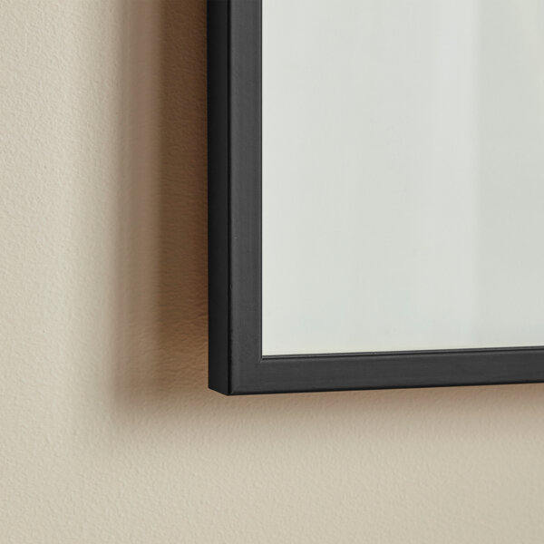 Corner segment of a slim black wood picture frame