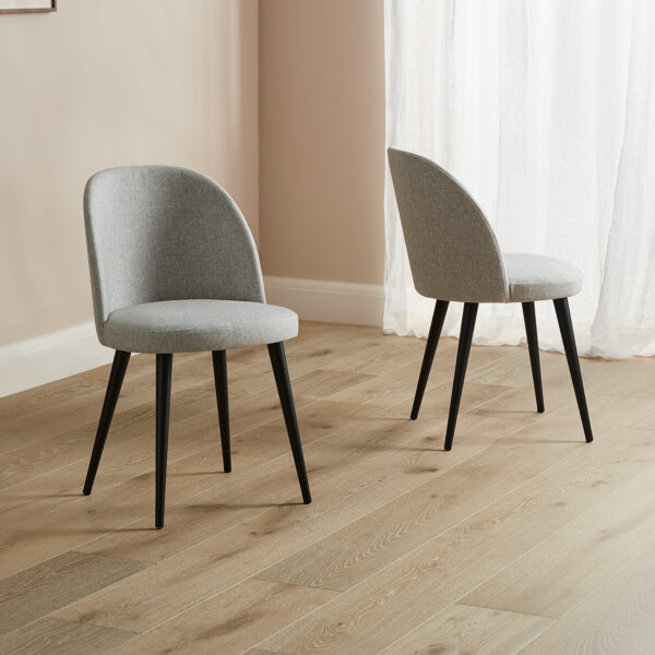 pair of grey fabric cup bad dining chairs with black wood legs