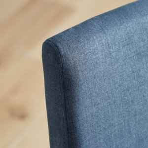 Selwood dining chairs in denim with natural wood legs placed on a wooden floor