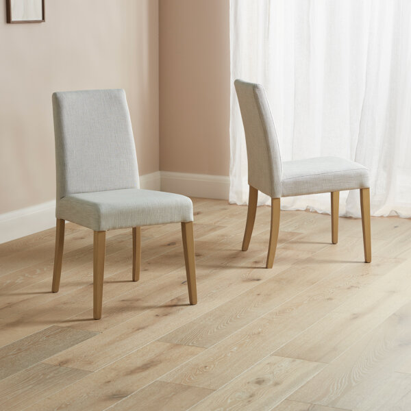 Selwood dining chairs in linen placed in a light room on a wooden floor
