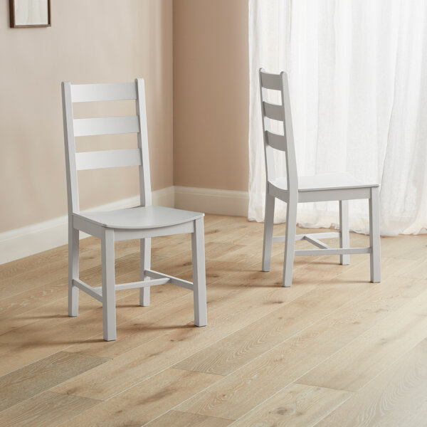 White dining rom chairs x 2 with strut backs sat on wood flooring